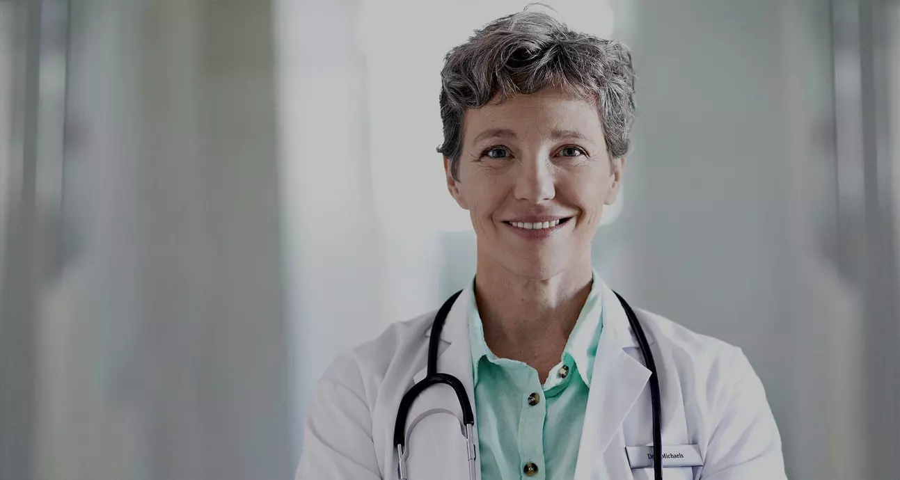 médica sorrindo com estetoscópio pendurado nos ombros