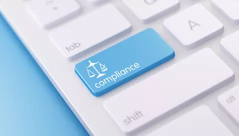 Teclado branco de computador com tecla fictíca em azul escrito "compliance"